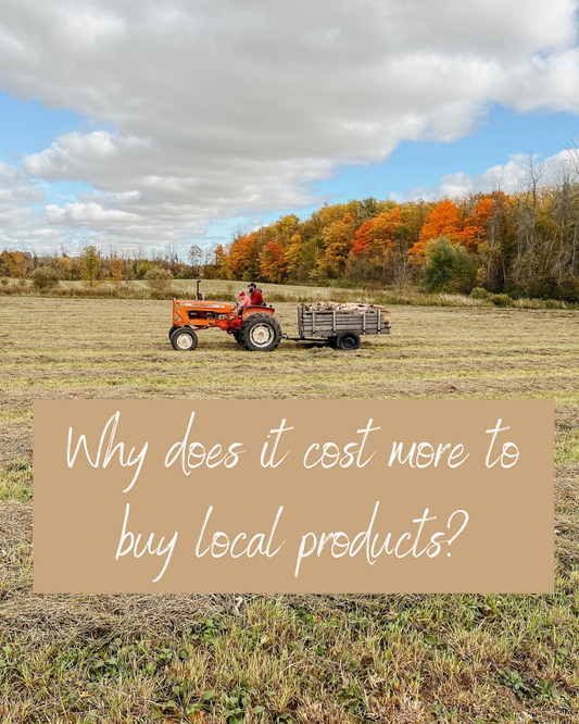 Alex and Matilda driving a tractor in the fall in front of colourful trees with the words 'Why does it cost more to buy local products' underneath